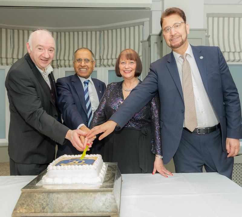 Current and former co-chairs cutting the anniversary cake